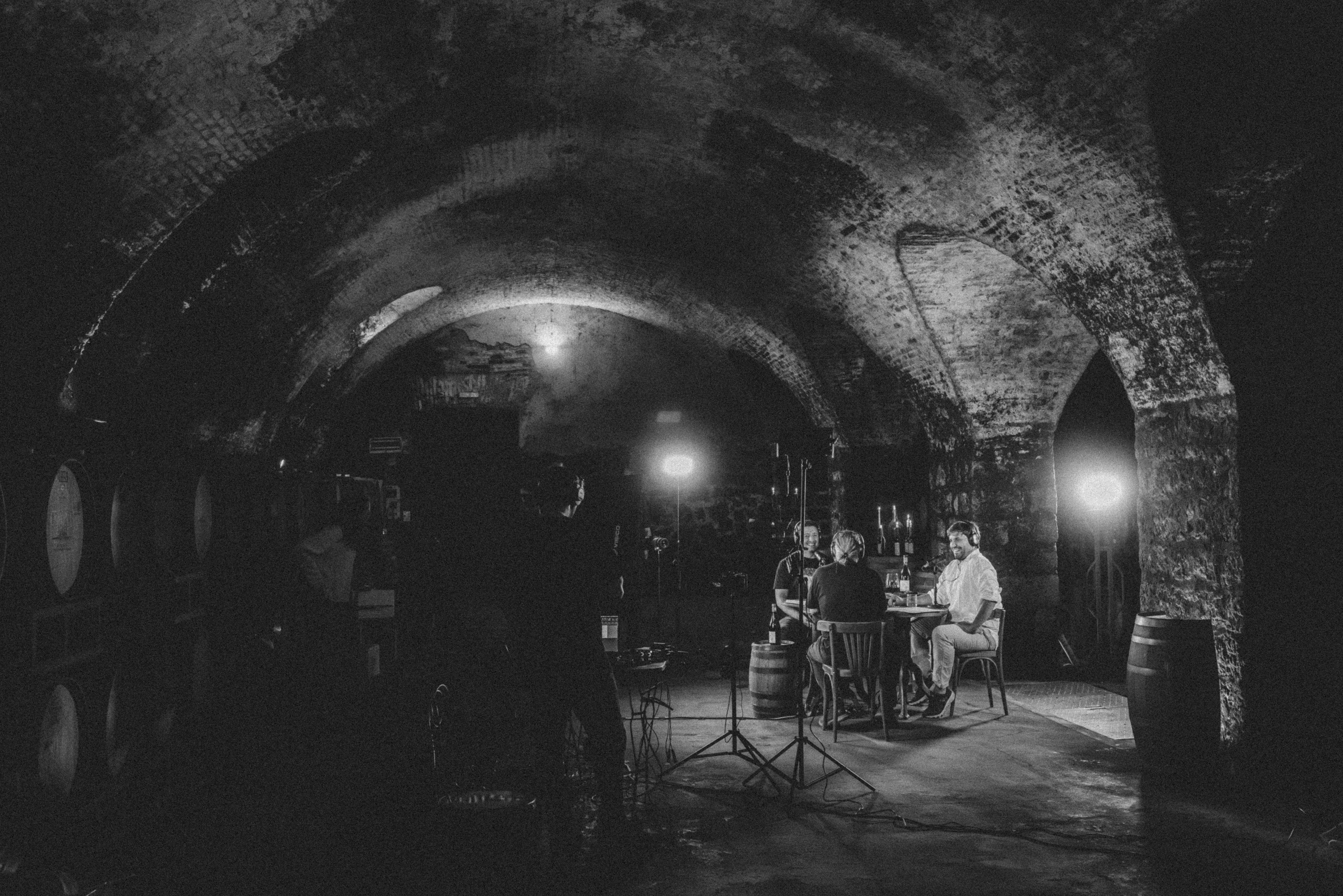 En blanco y negro, los arcos de piedra con la mesa y las luces de rodaje